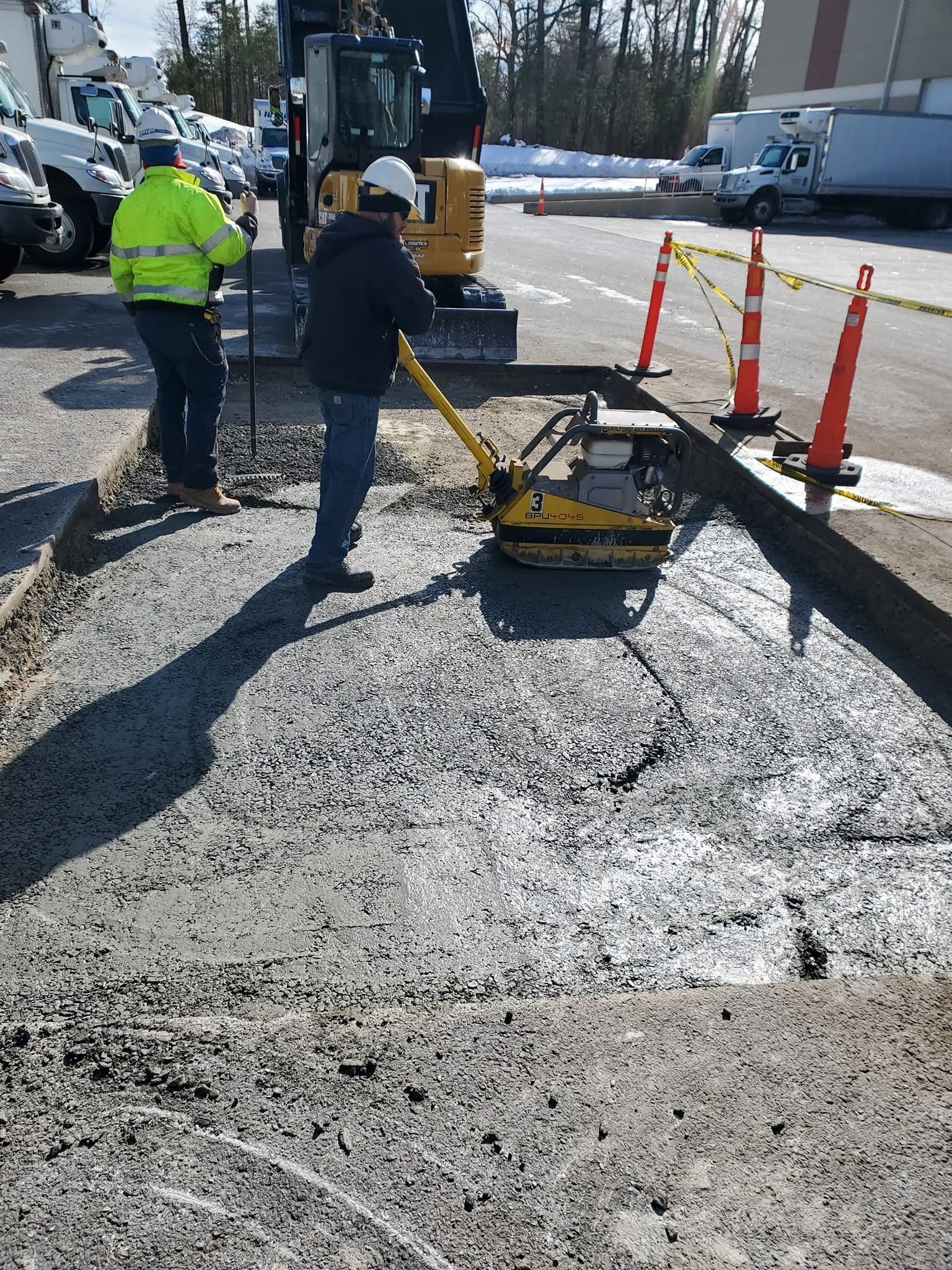 A group of construction workers are working on a road.