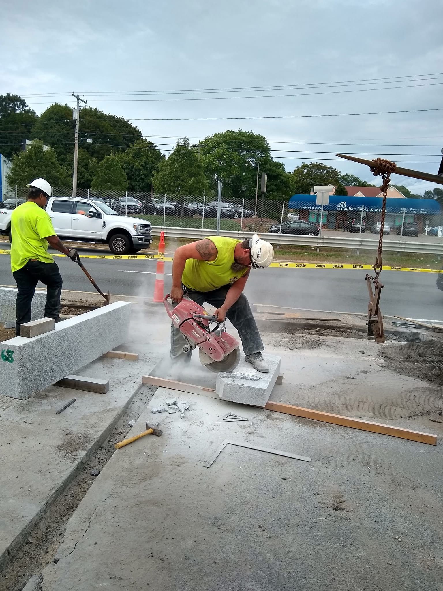 A construction worker is cutting concrete with a circular saw.