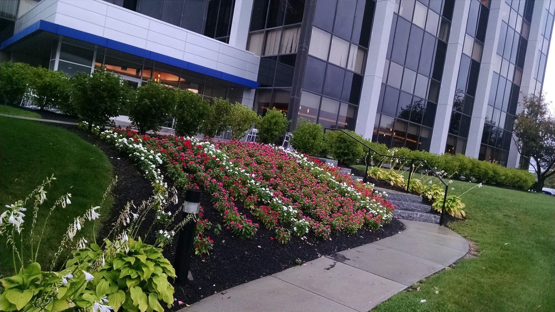 A large building with a lot of flowers in front of it