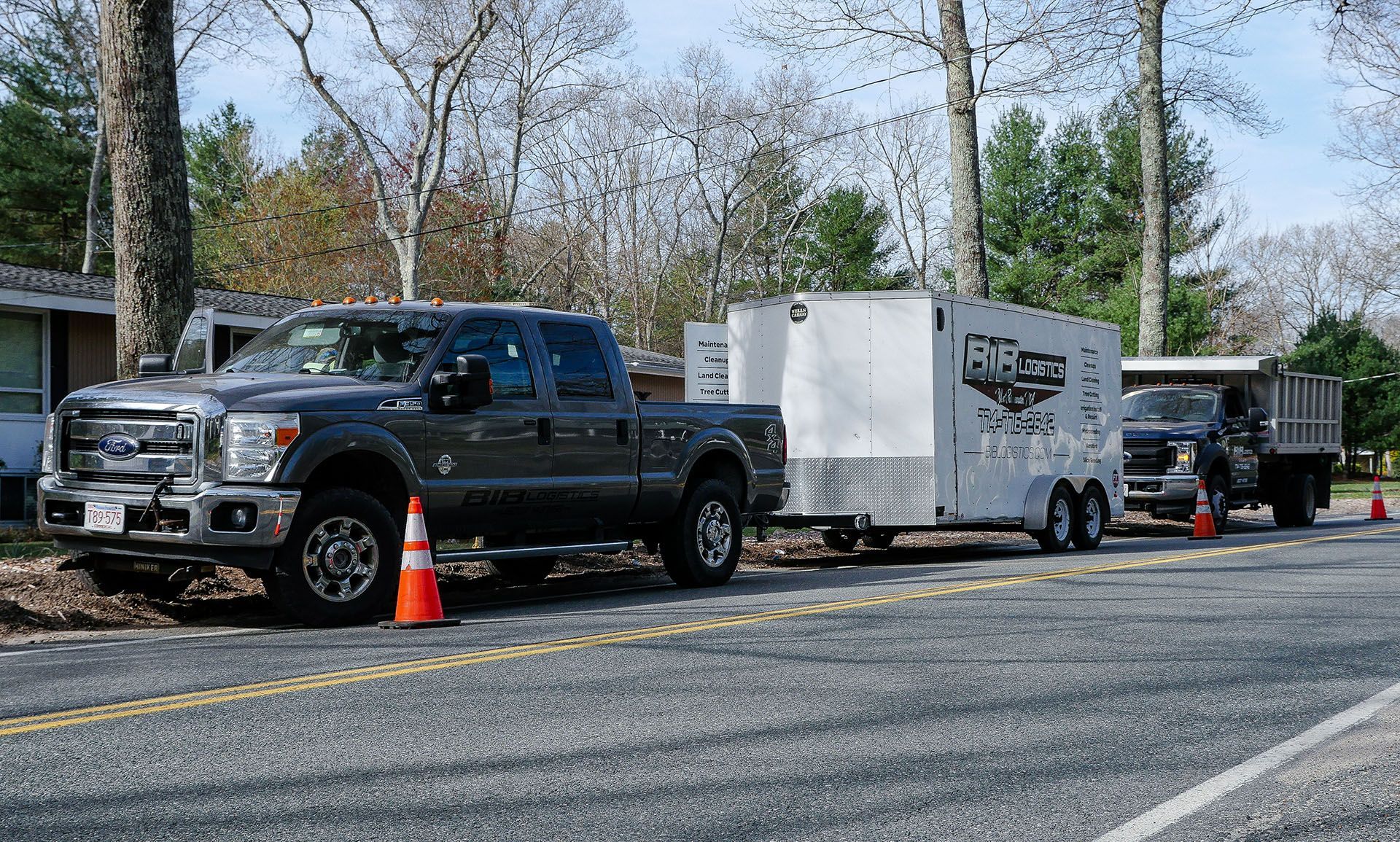 A truck with a trailer attached to it is parked on the side of the road.
