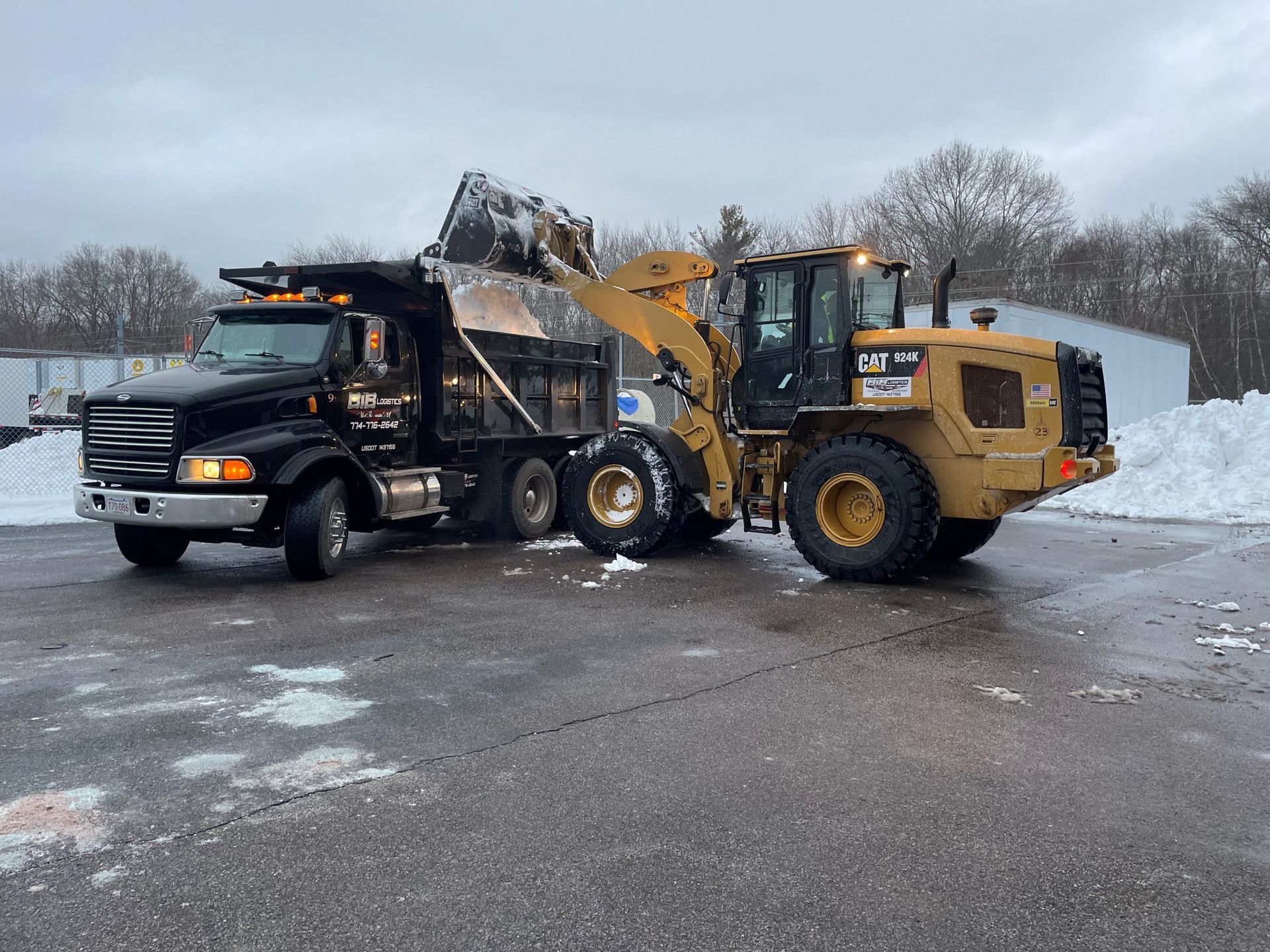 A dump truck and a wheel loader are parked in a parking lot.