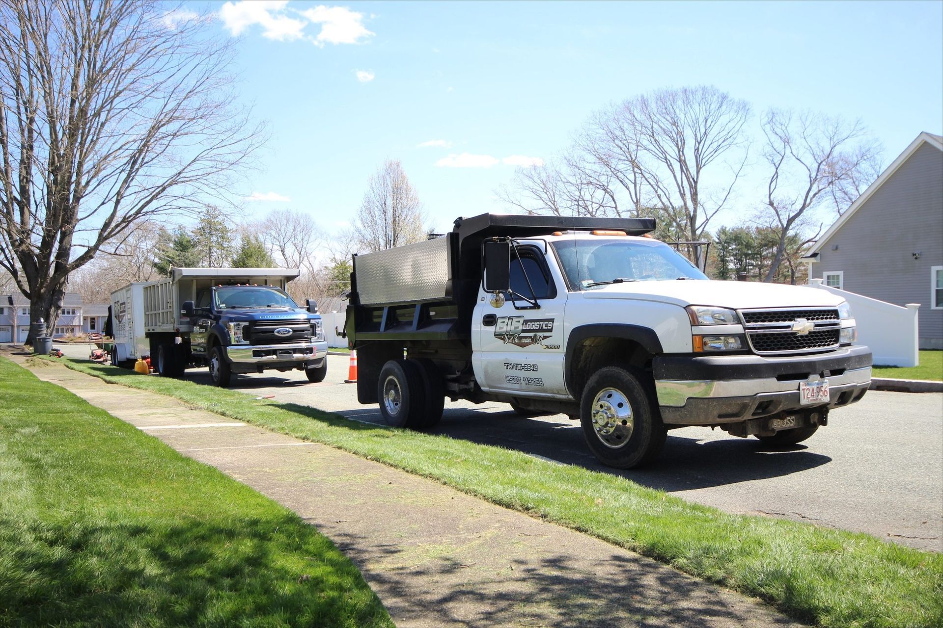 Two dump trucks are parked on the side of the road.