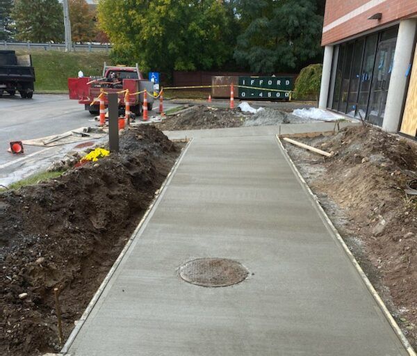 A concrete walkway is being built in front of a building