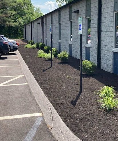 A parking lot with cars parked in front of a building.