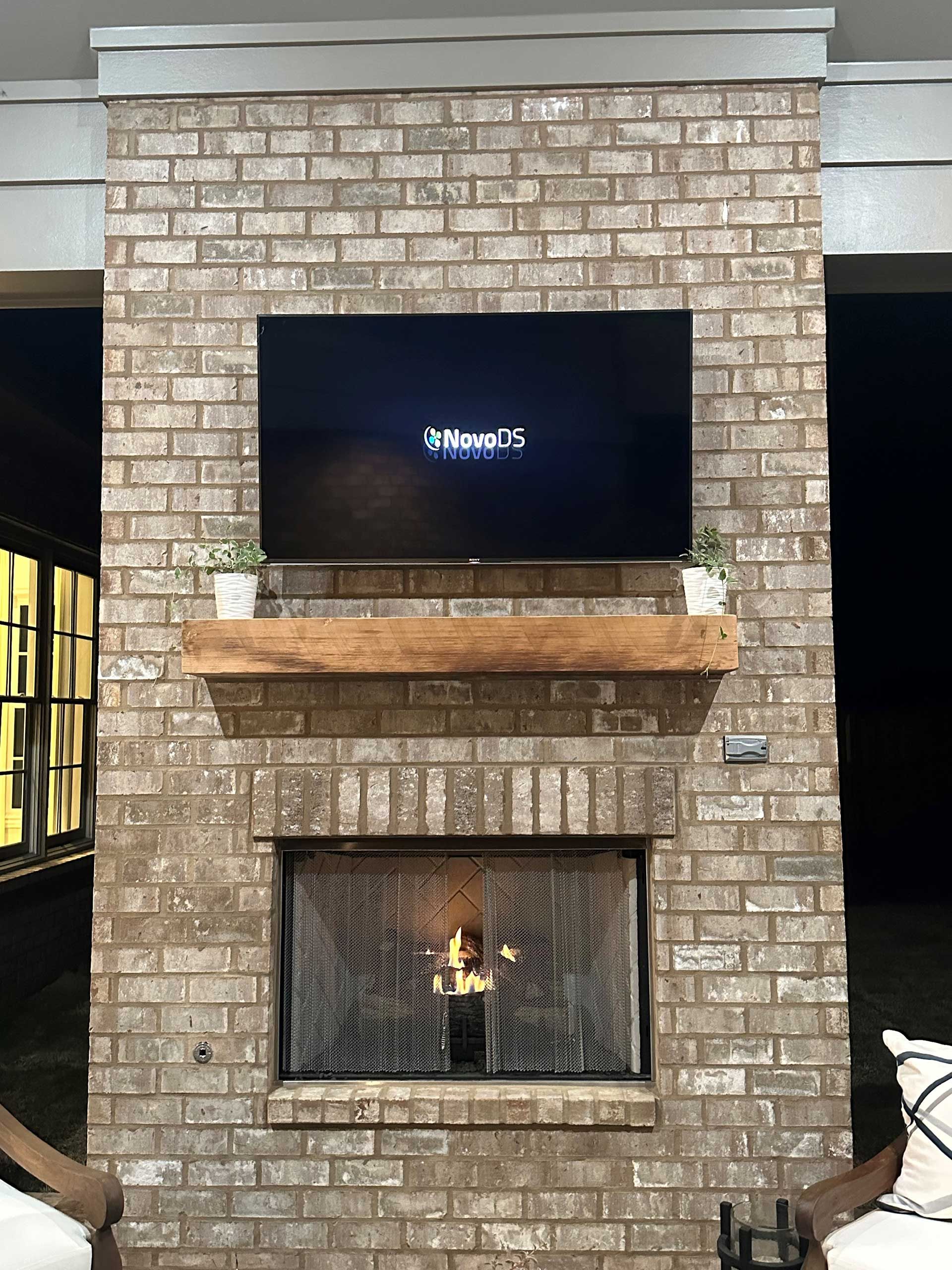 A brick fireplace with a flat screen tv mounted above it