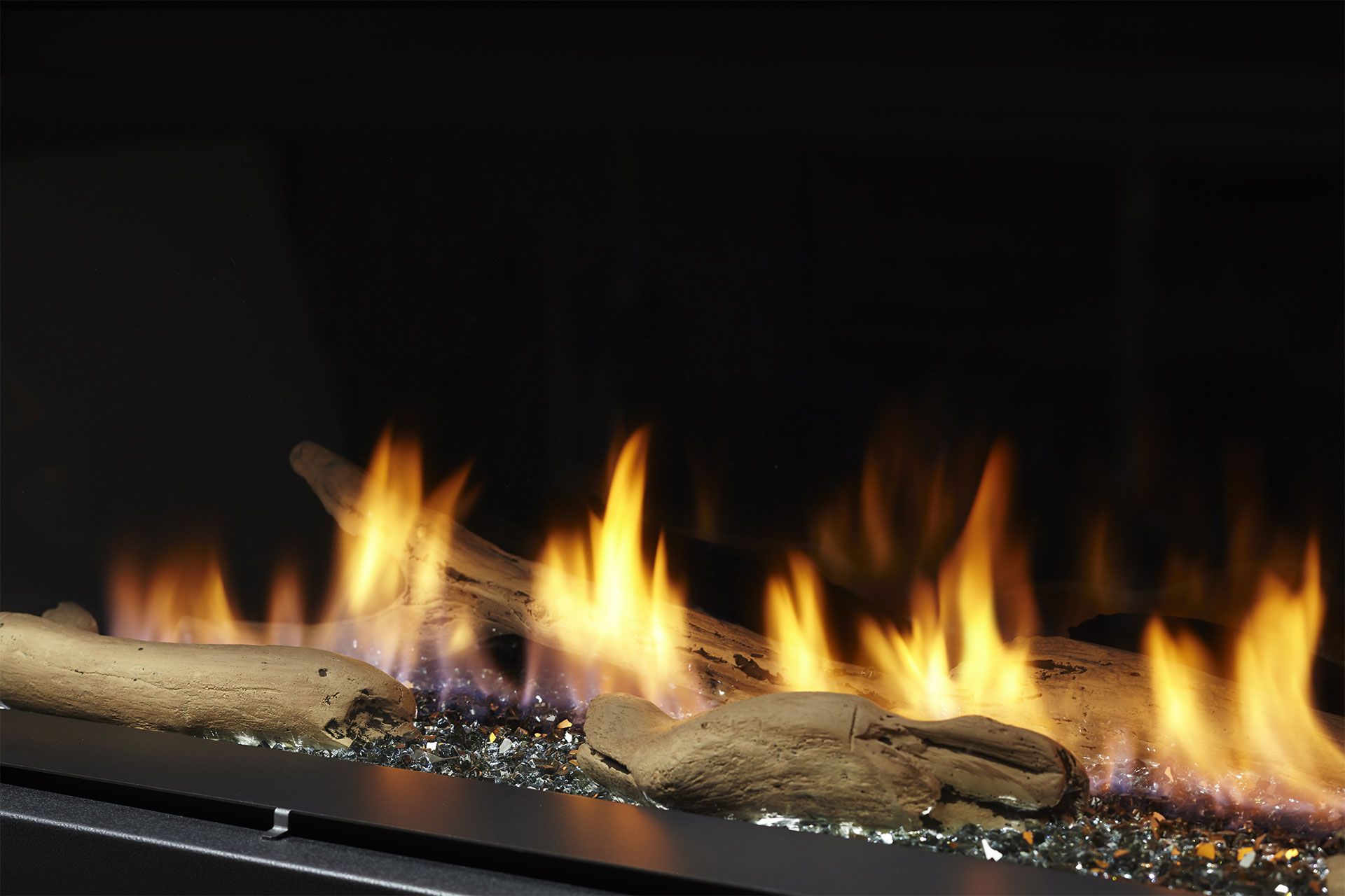 Fireplace with flames and decorative driftwood logs.