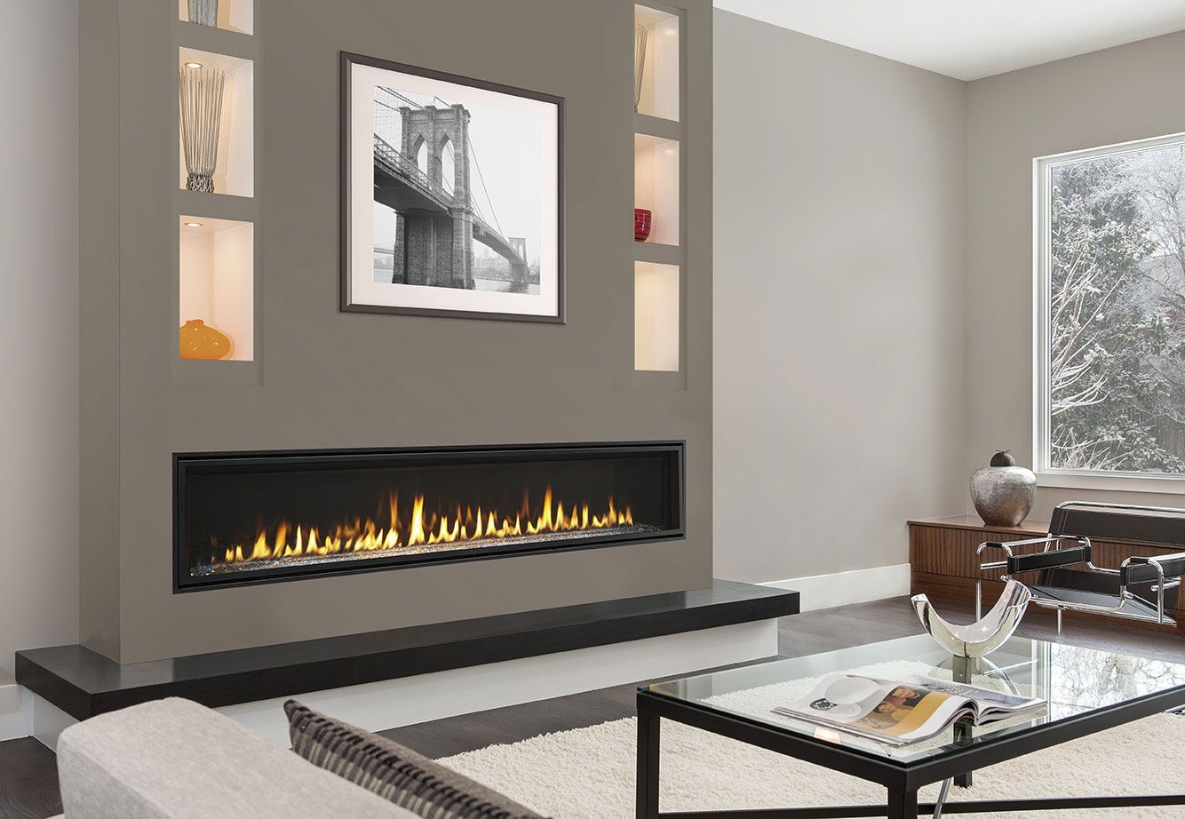Modern living room with fireplace, built-in shelves, framed artwork, and a glass coffee table.