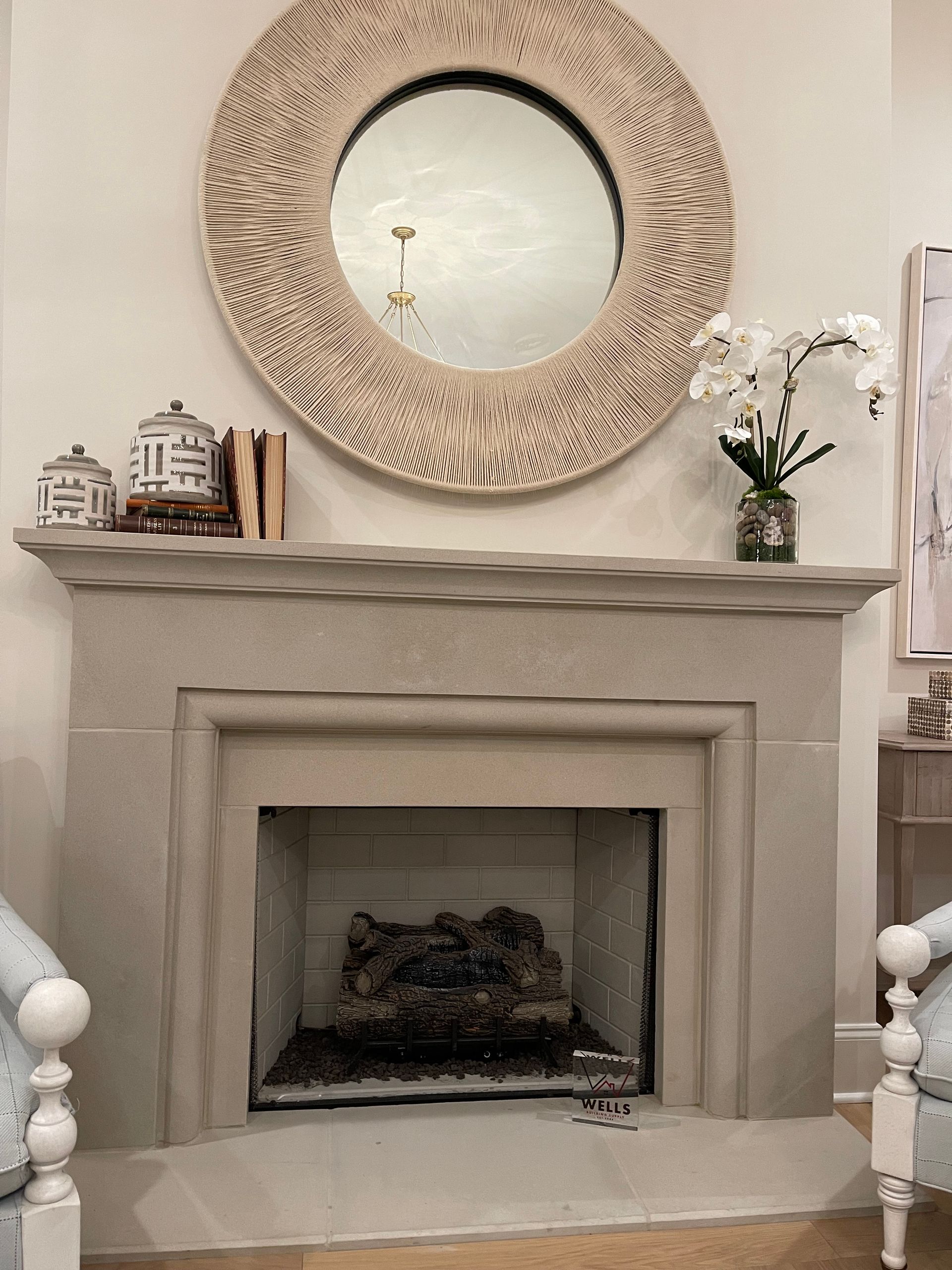Fireplace with decorative mirror and accessories, featuring a neutral color palette.