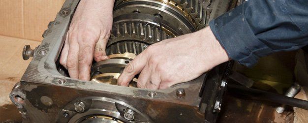 a mechanic fixing car transmission