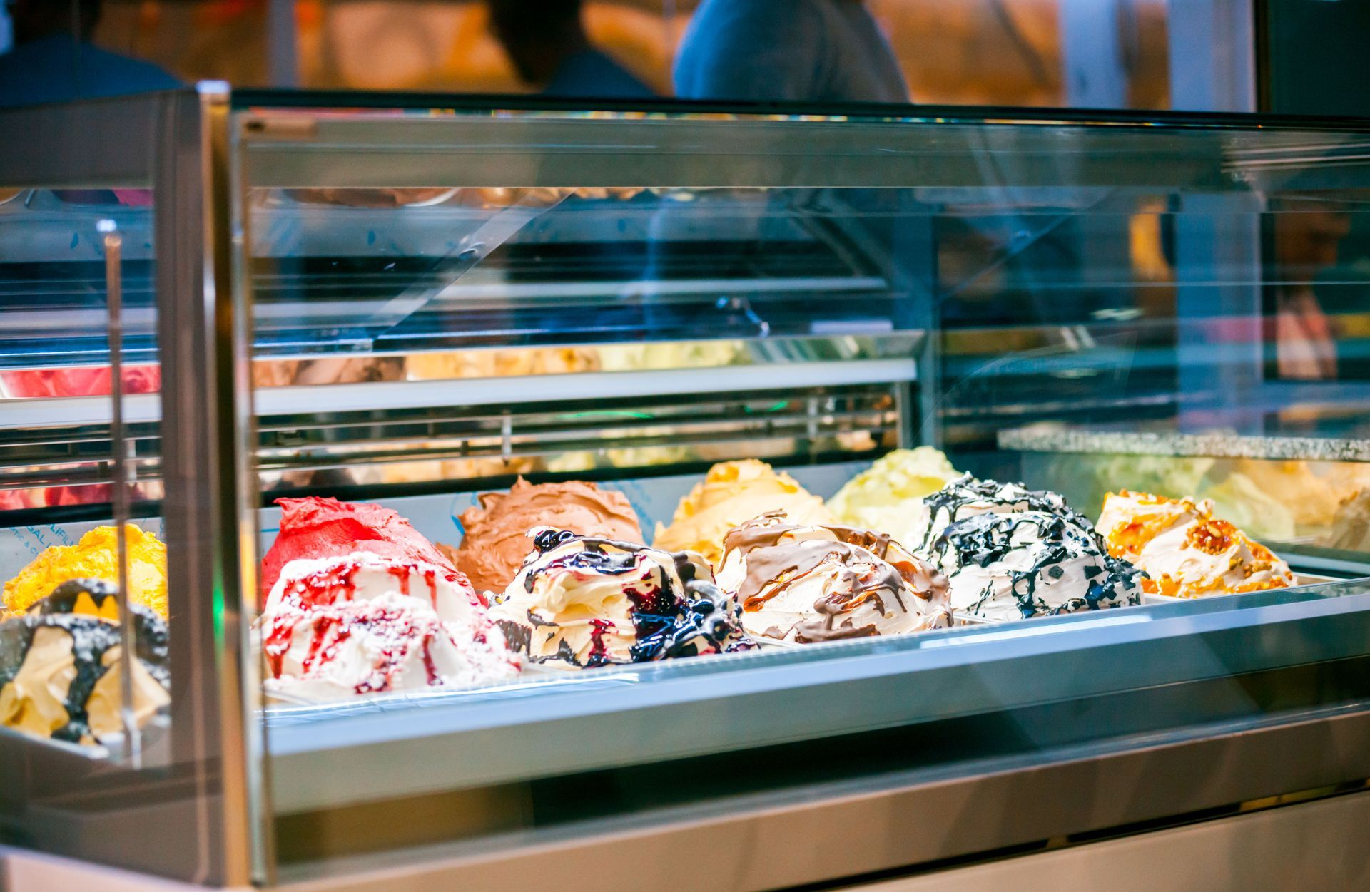 Glass display case with colorful scoops of ice cream in a shop