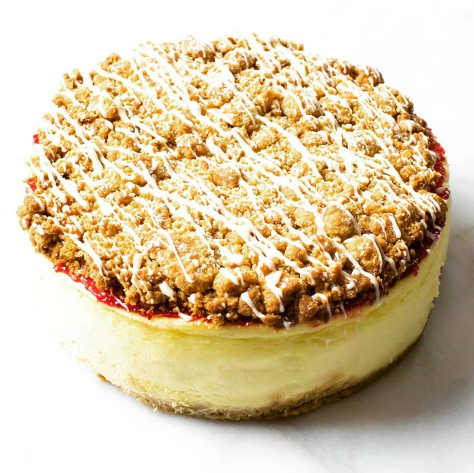 Round crumb-topped cheesecake on a white background