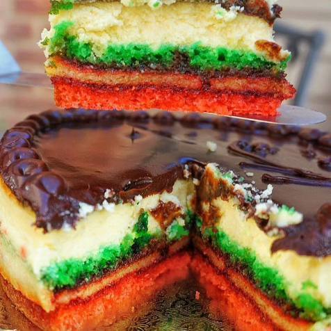 Chocolate-glazed layered cake with green and red stripes, sliced to show the colorful interior.
