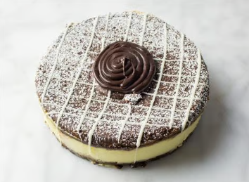 Chocolate frosted round cake with white drizzle and a chocolate rosette on top