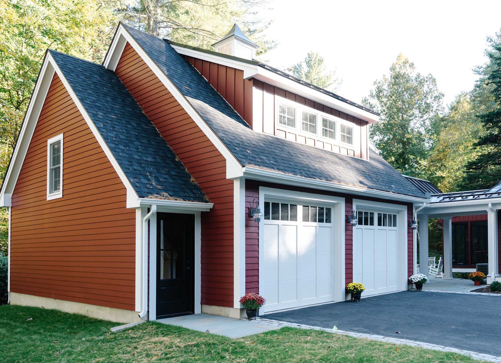 Red garage with white doors, black roof, and small cupola.