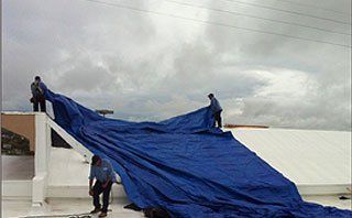 A group of workers removing the cover of a finished roof
