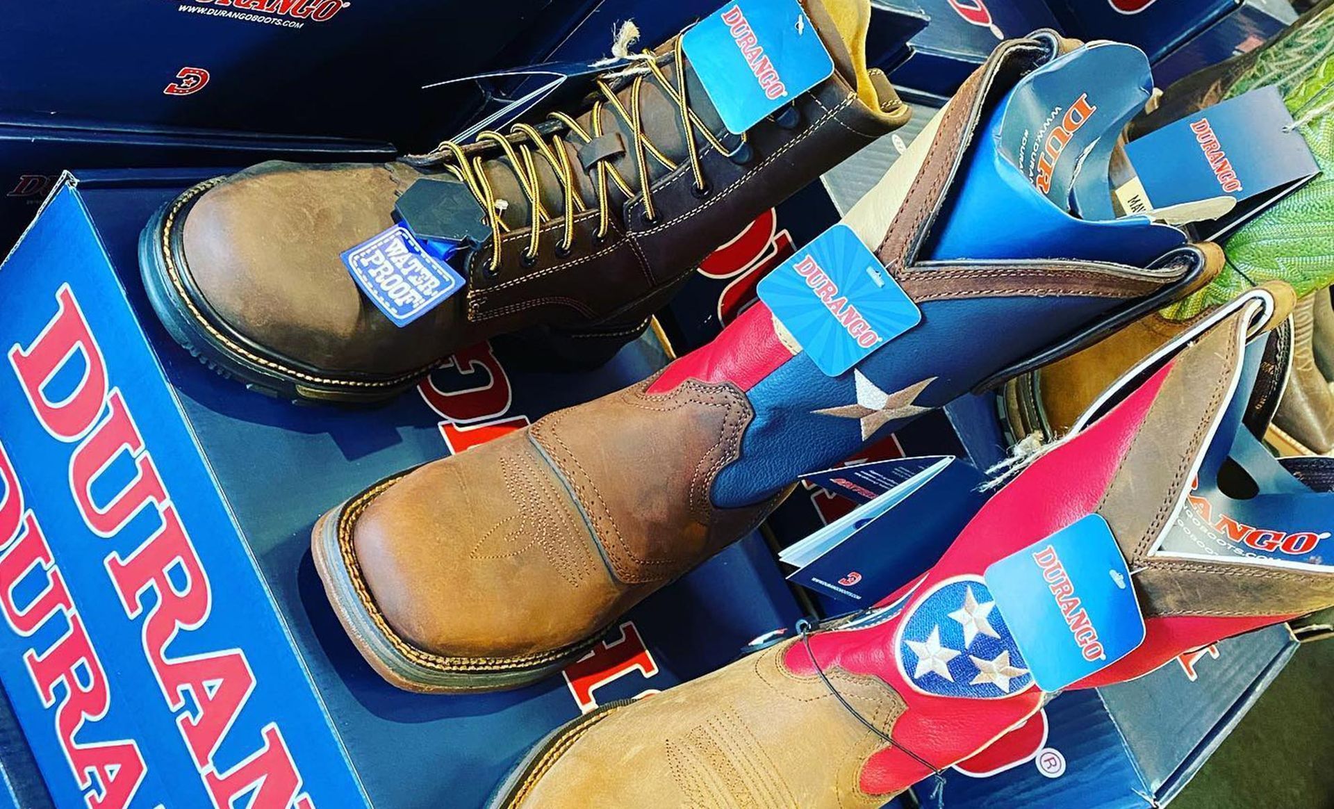 Several pairs of cowboy boots are stacked on top of each other