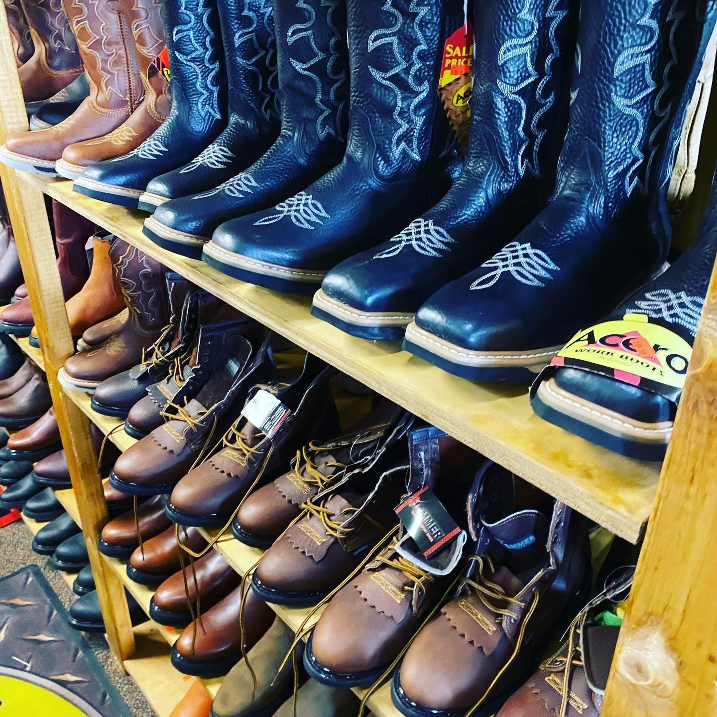 A row of cowboy boots are lined up on a shelf