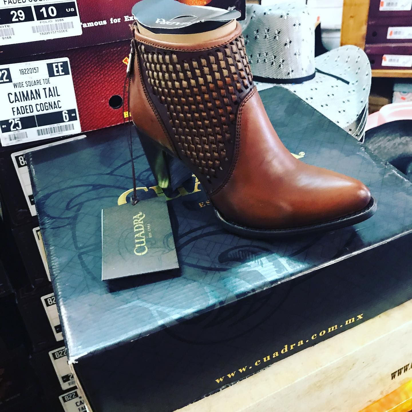 A pair of brown cuadra boots sitting on top of a box