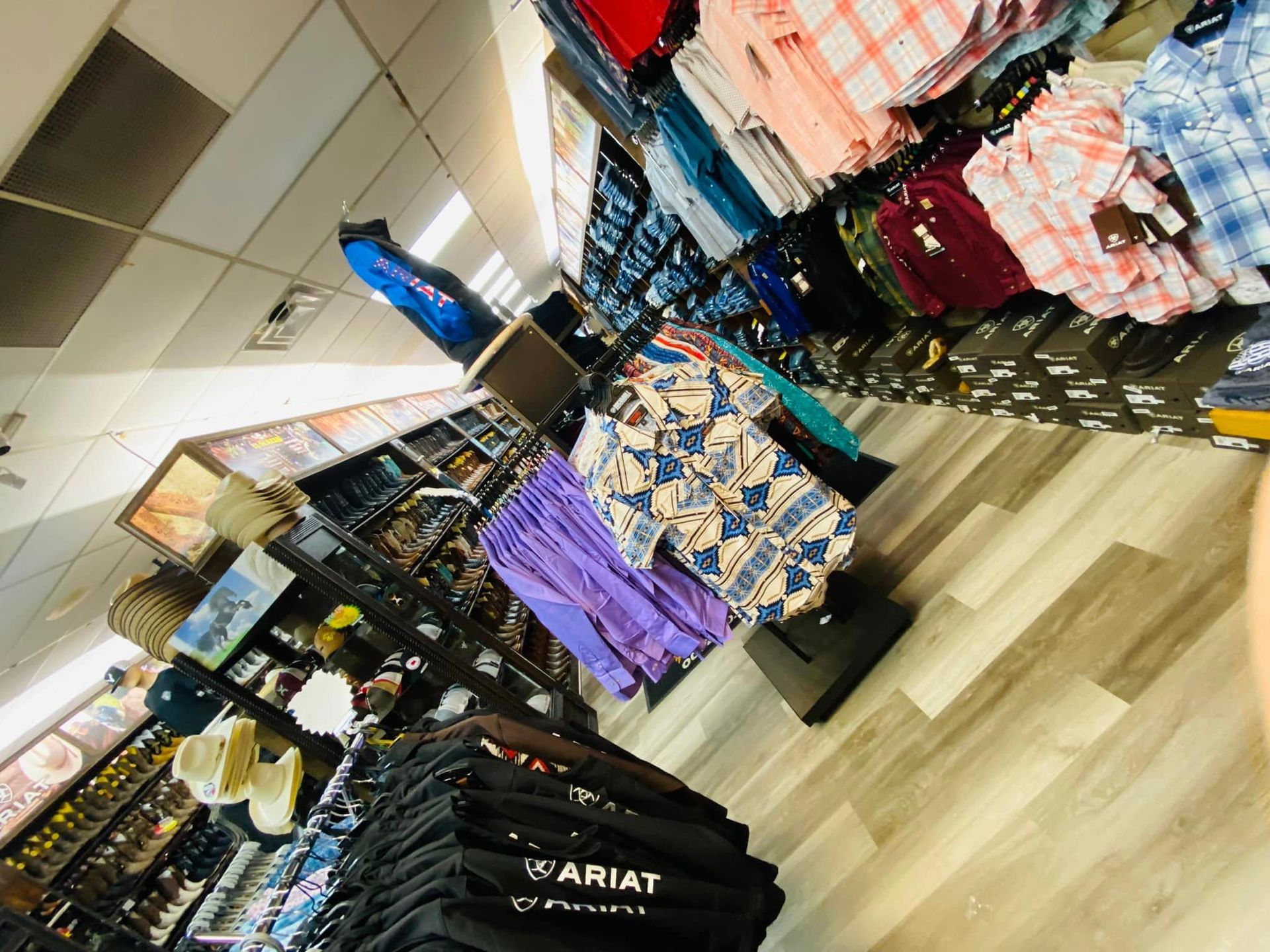 A person is standing in a store looking at clothes on display.