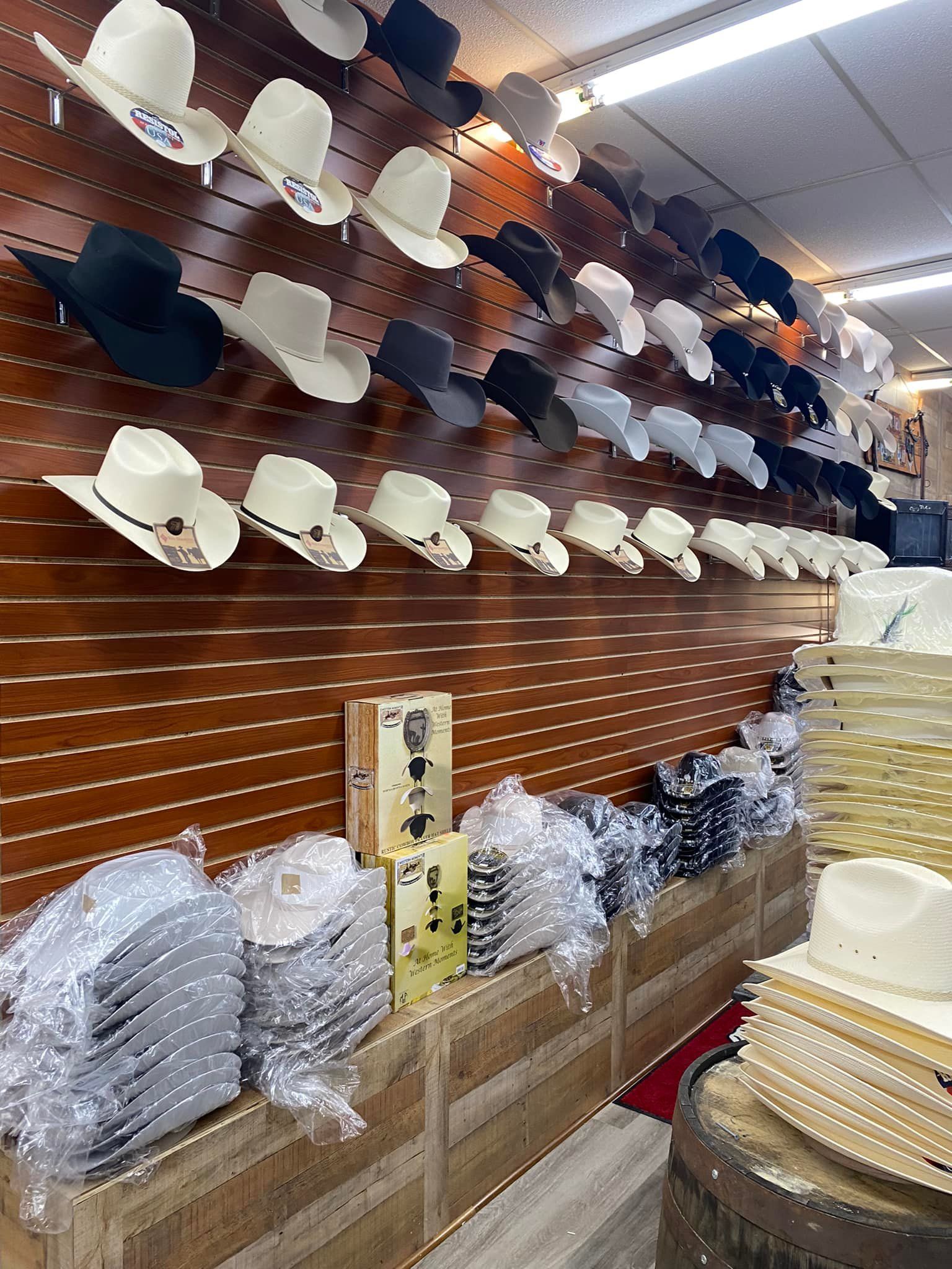 A row of cowboy hats hanging on a wall in a store.