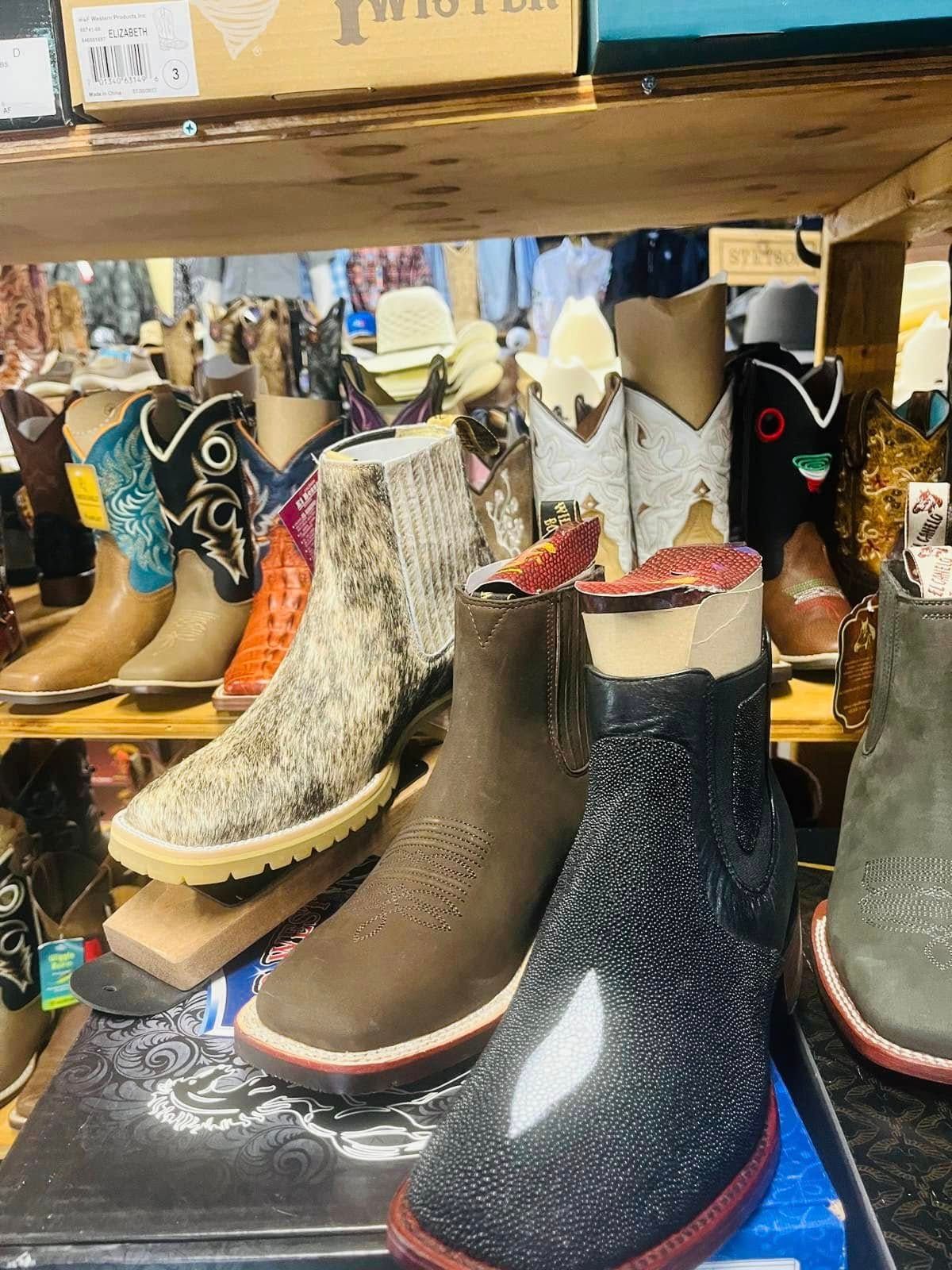 A display of cowboy boots on a shelf in a store.