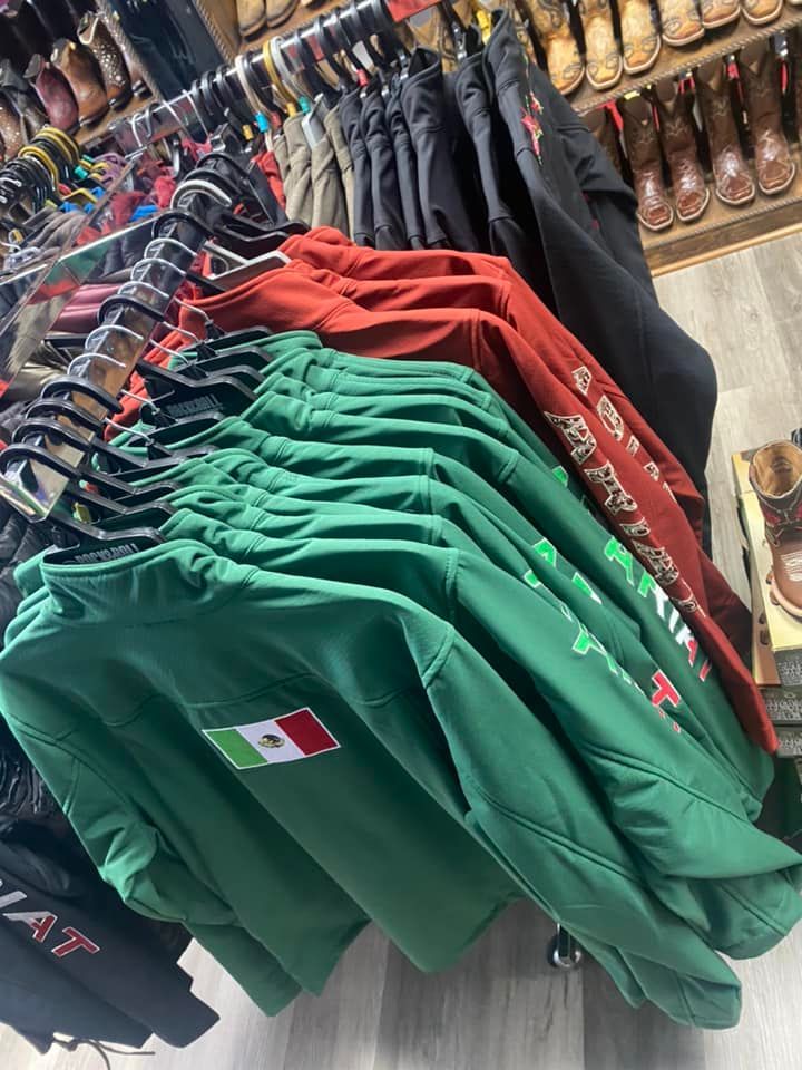 A bunch of shirts are hanging on a rack in a store.