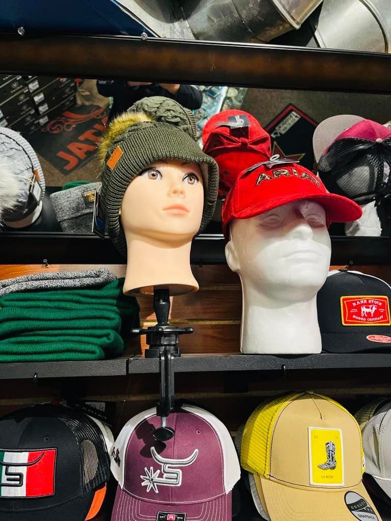 A display of hats on mannequin heads in a store