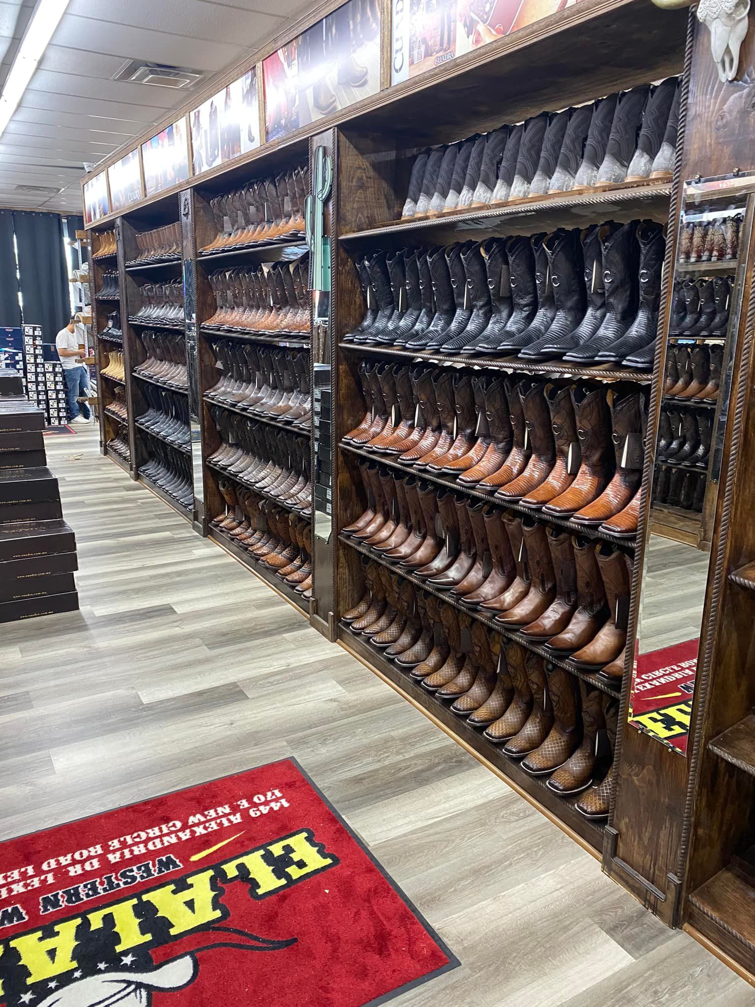 A row of shelves filled with lots of cowboy boots in a store.