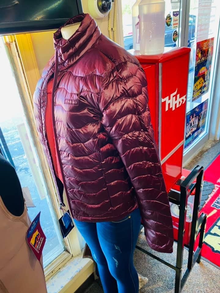 A purple jacket is on a mannequin in a store.