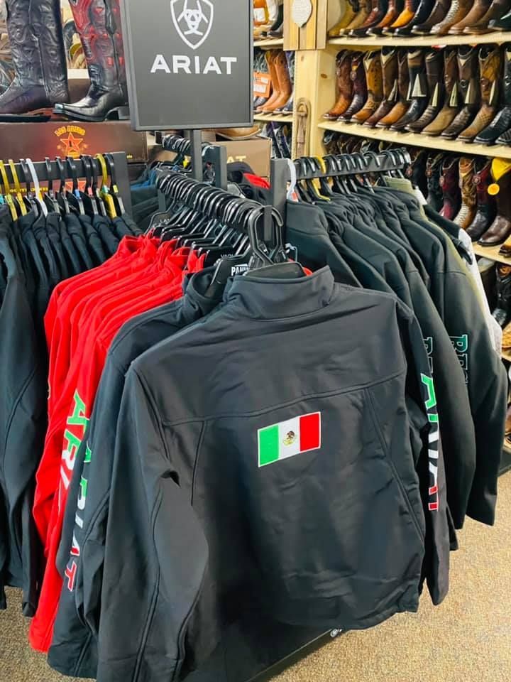 A bunch of jackets are hanging on a rack in a store.