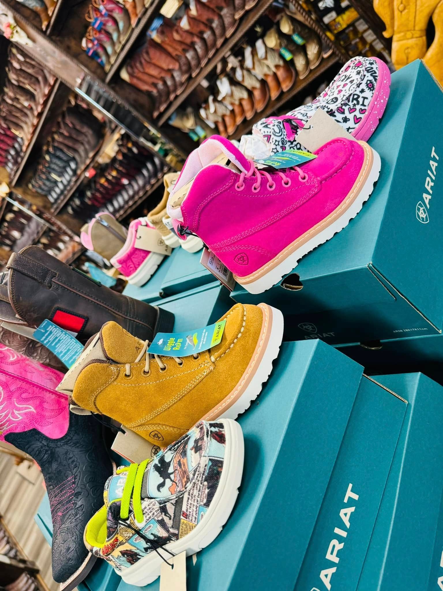 A bunch of shoes are sitting on top of boxes in a store.