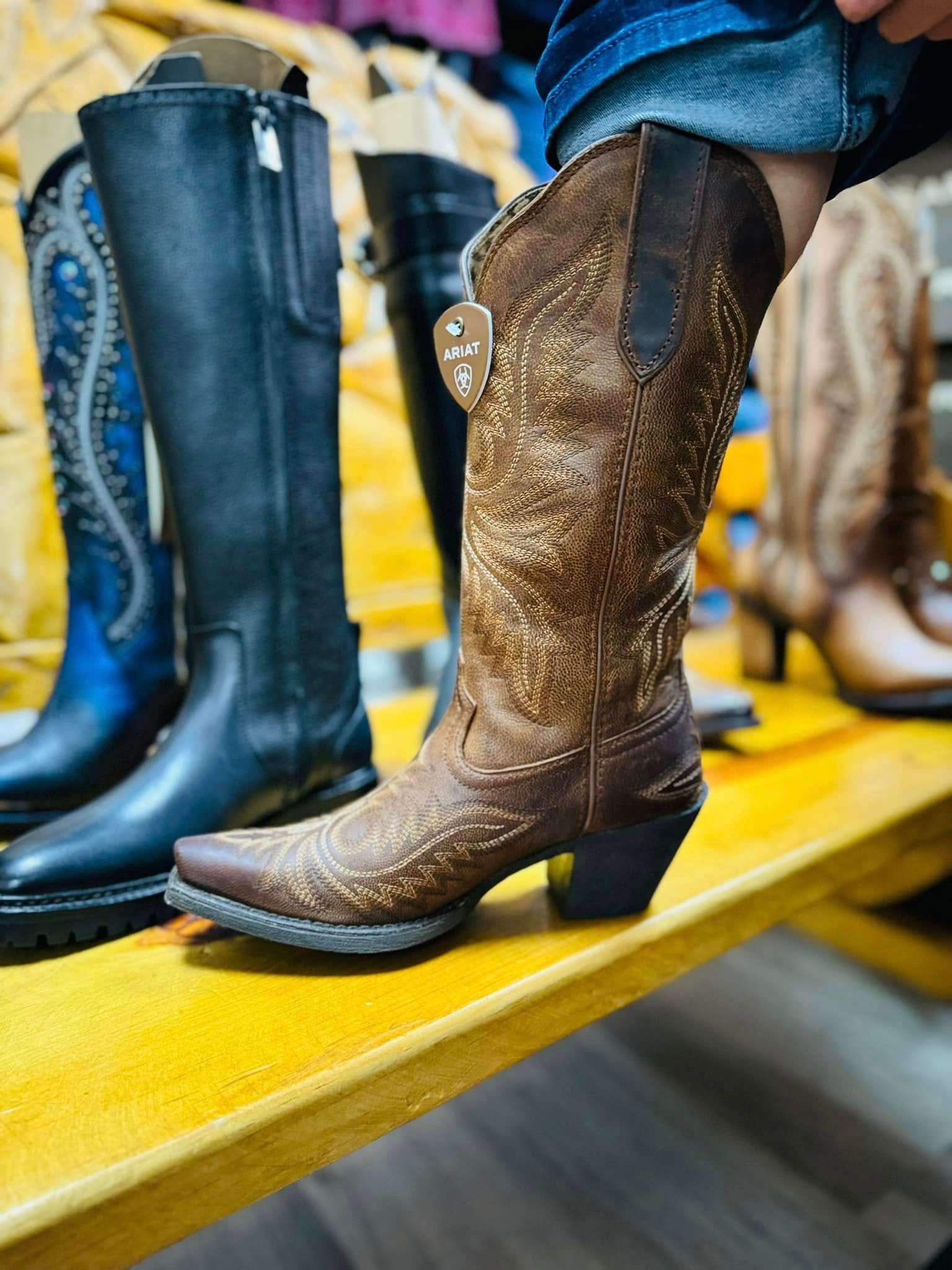 A person is trying on a pair of cowboy boots.