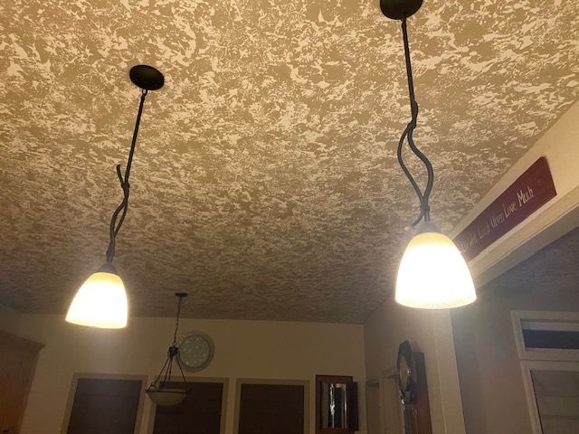 Two lights are hanging from the ceiling of a room