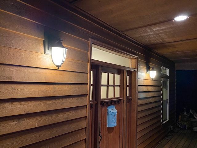 A wooden house with a blue mailbox on the door