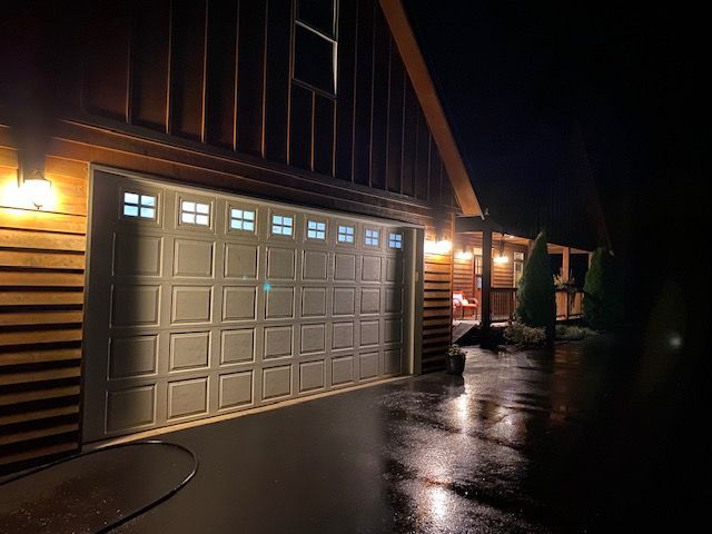 A garage door is open in front of a house at night