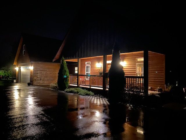 A house with a porch is lit up at night
