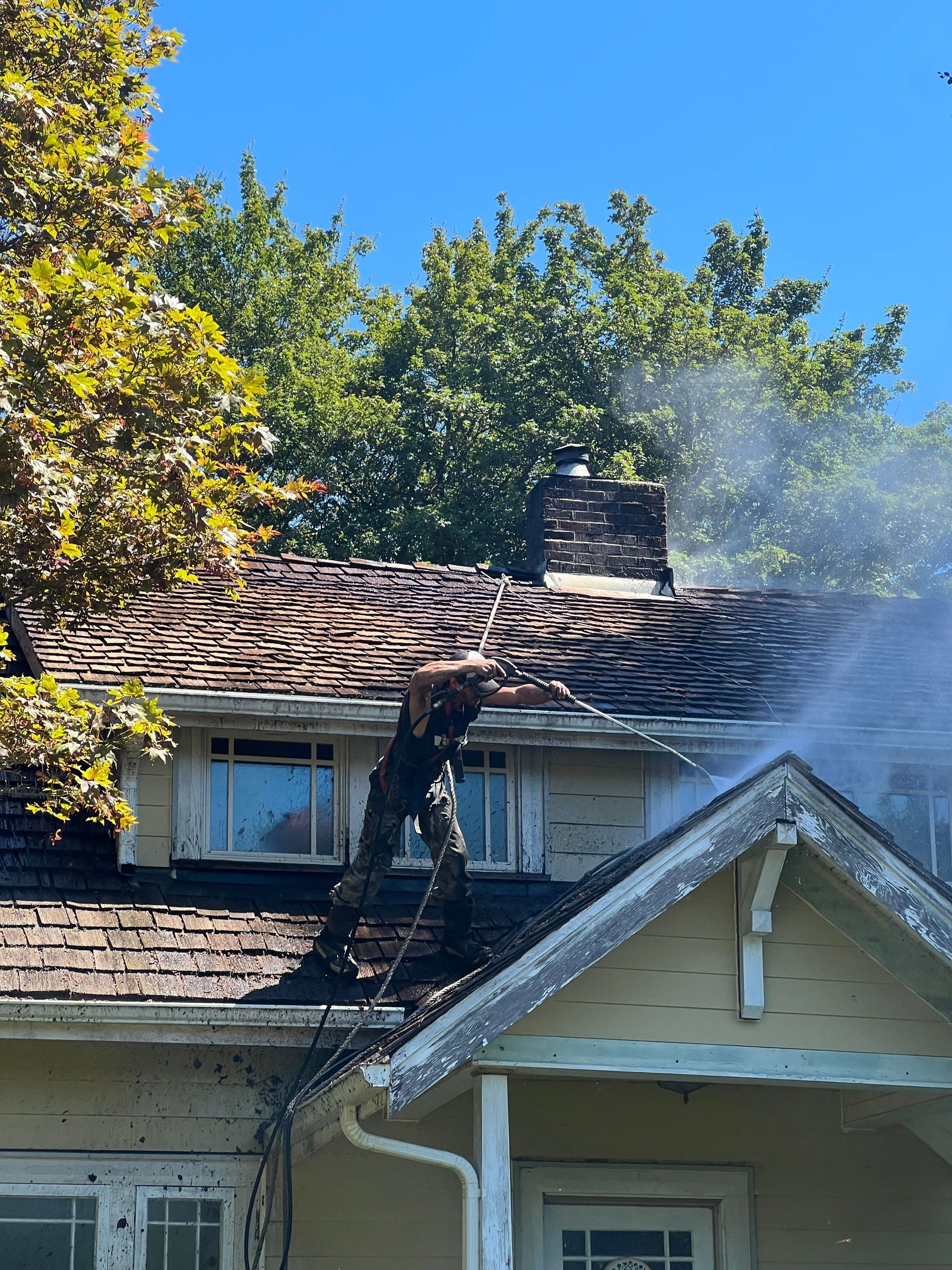 a man is cleaning the roof of a house.