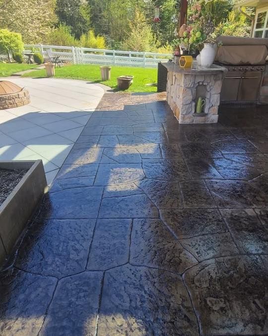a patio with a concrete floor and a fence in the background