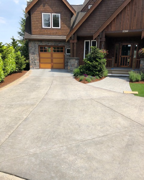 a house with a concrete driveway and a wooden garage door