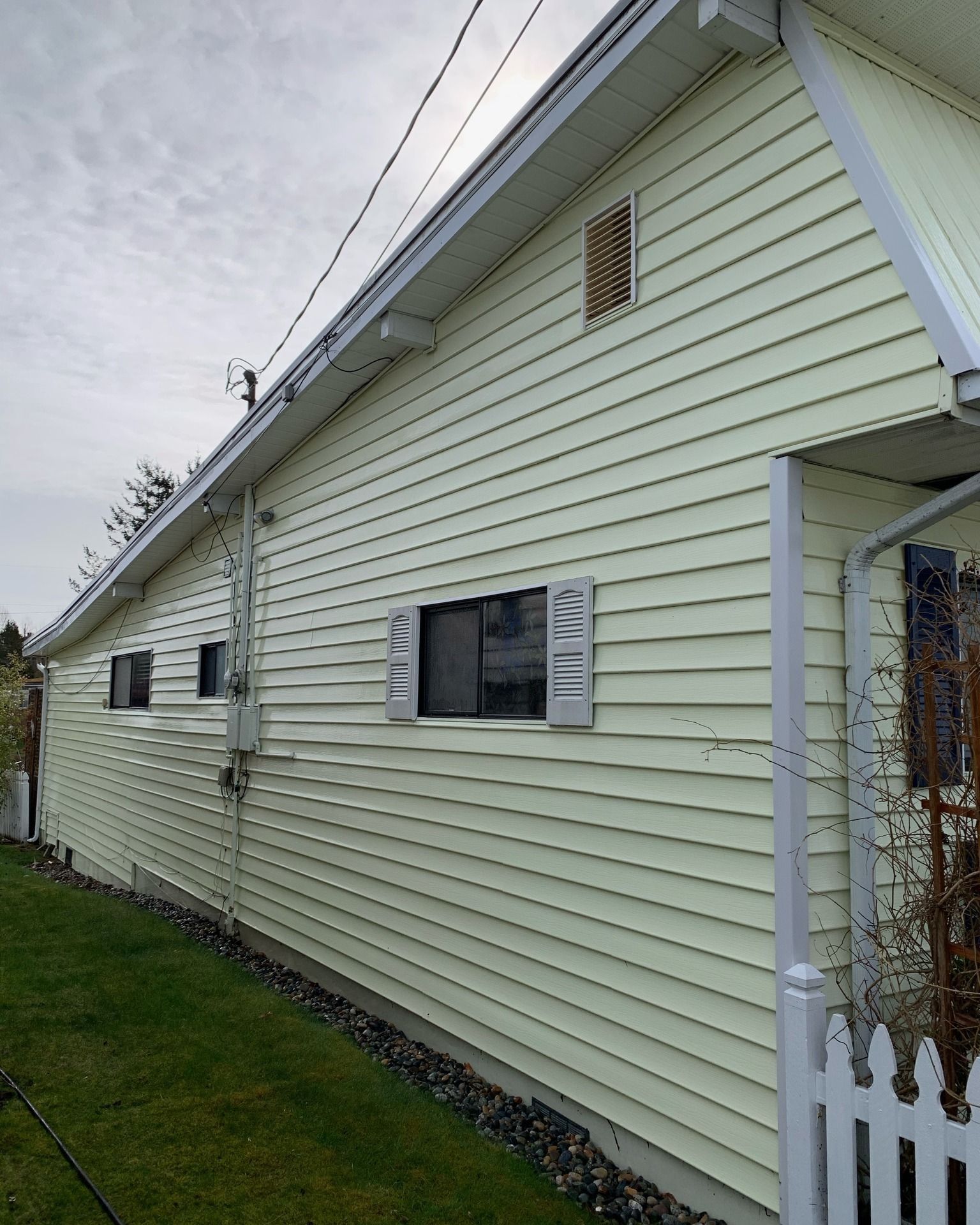 a house with a white siding and a white fence