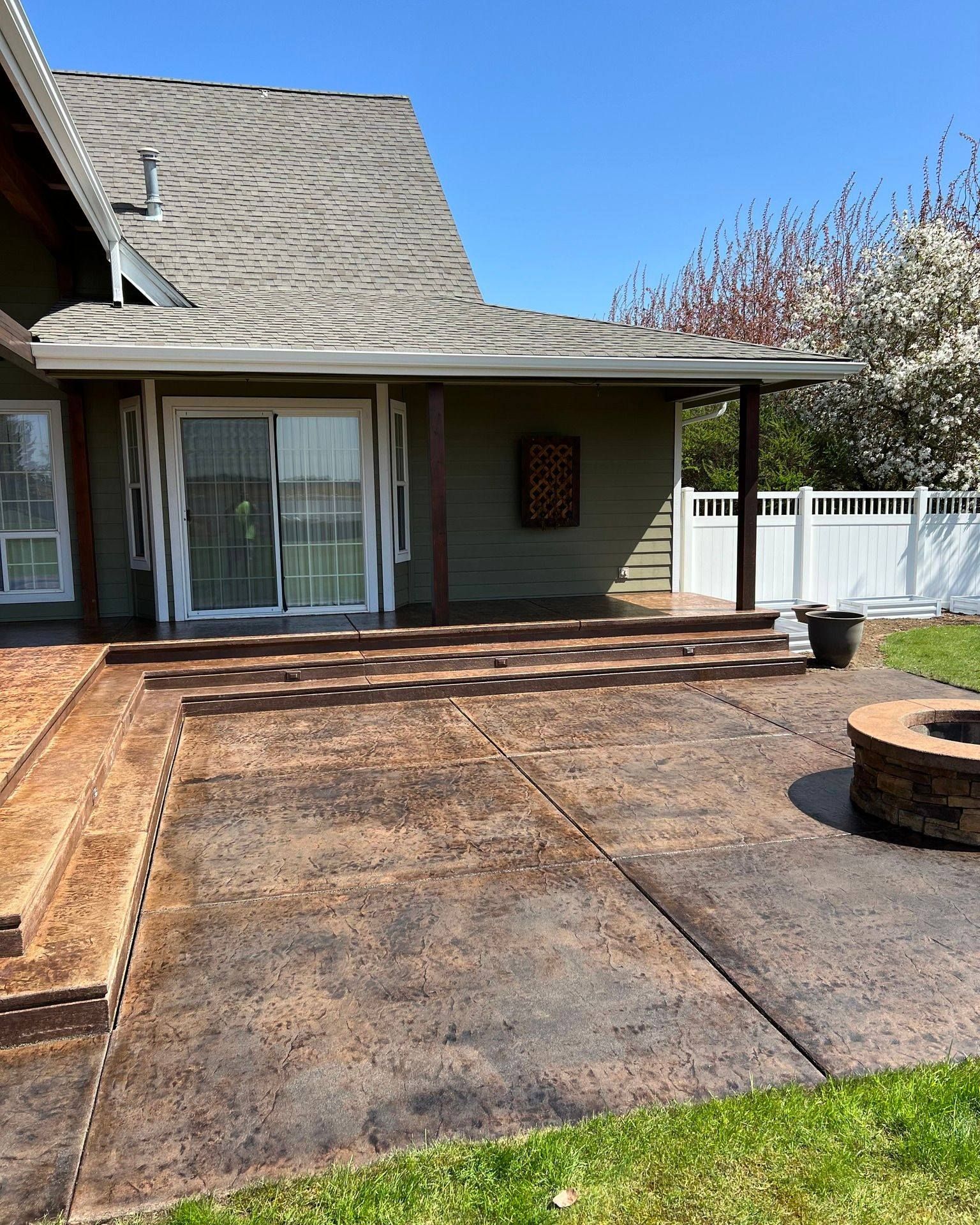 a house with a patio and a fire pit in front of it