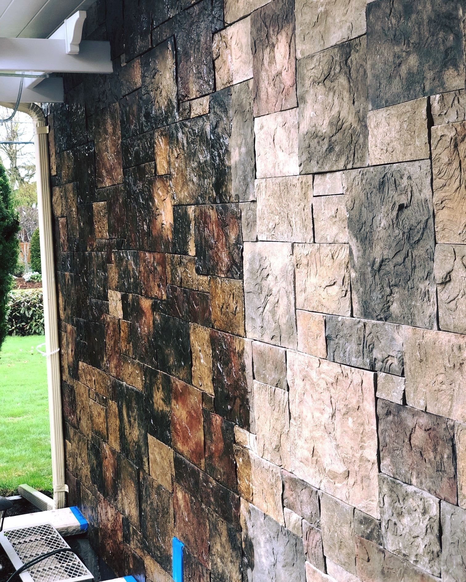 a stone wall is being painted on a house
