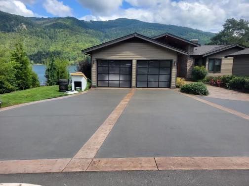 a large house with a driveway leading to it and mountains in the background .