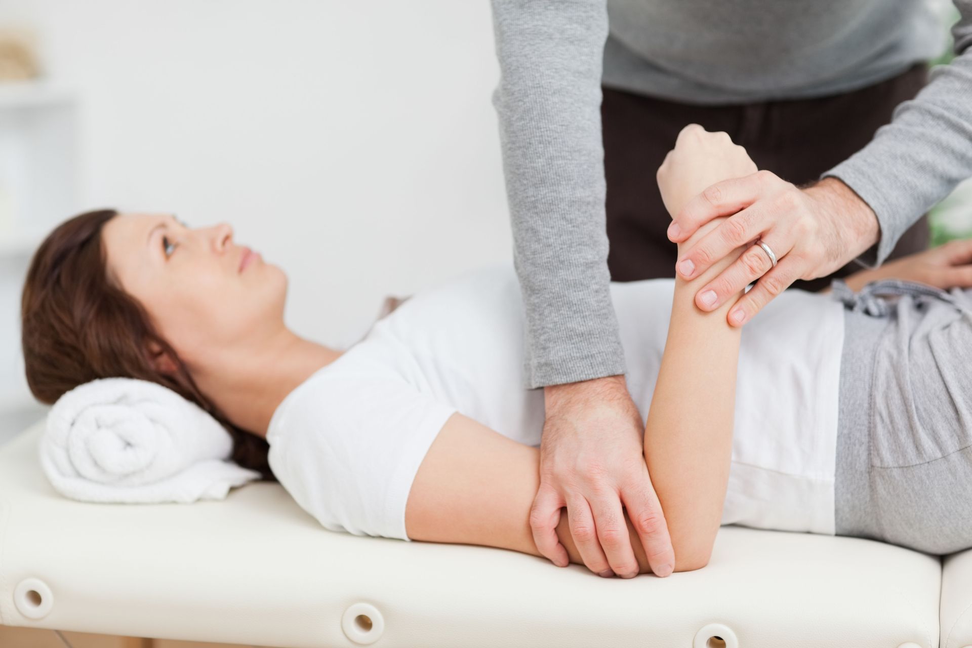 A woman is laying on a table getting a massage from a man.