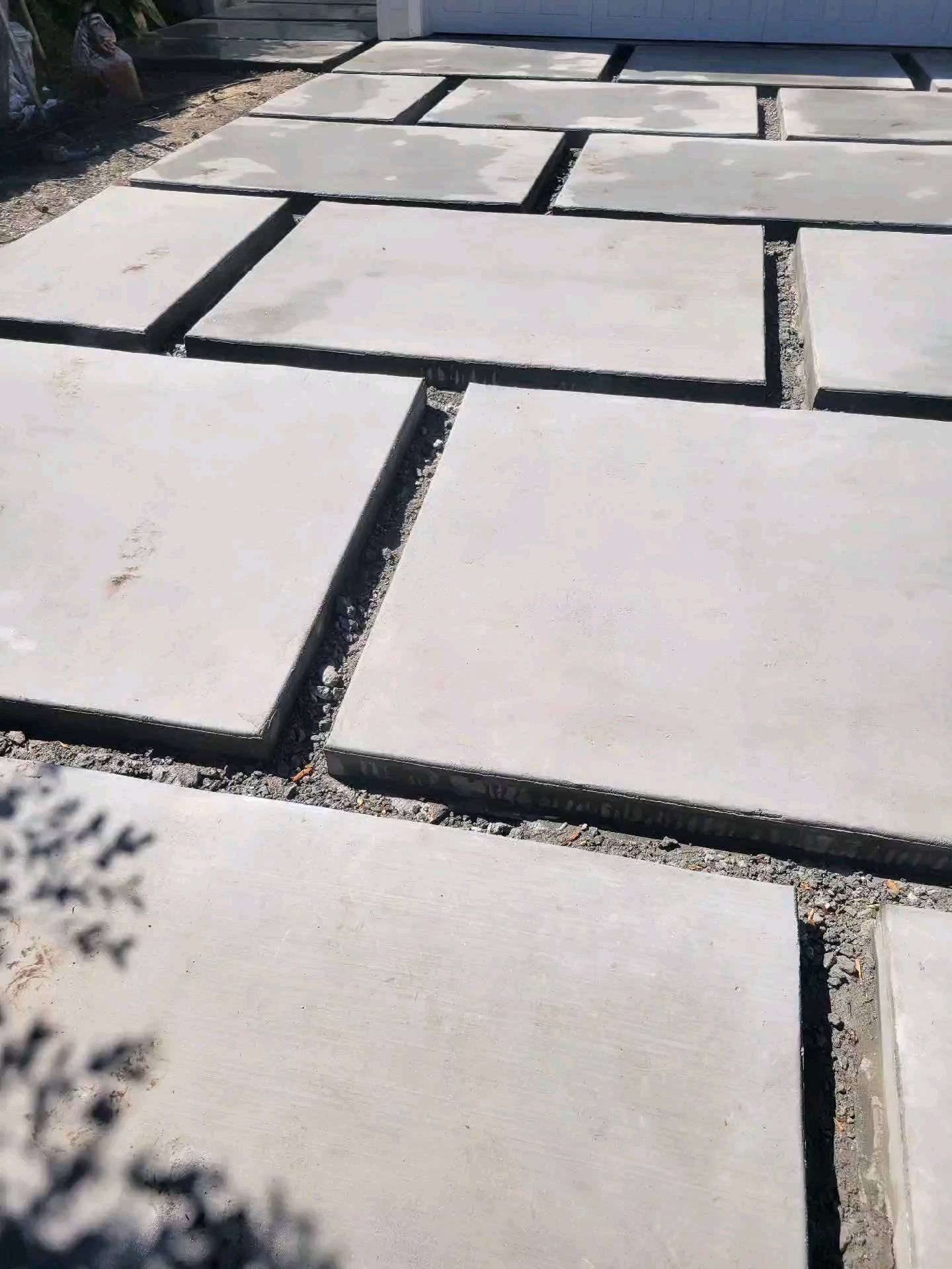 A concrete walkway with a lot of square tiles on it