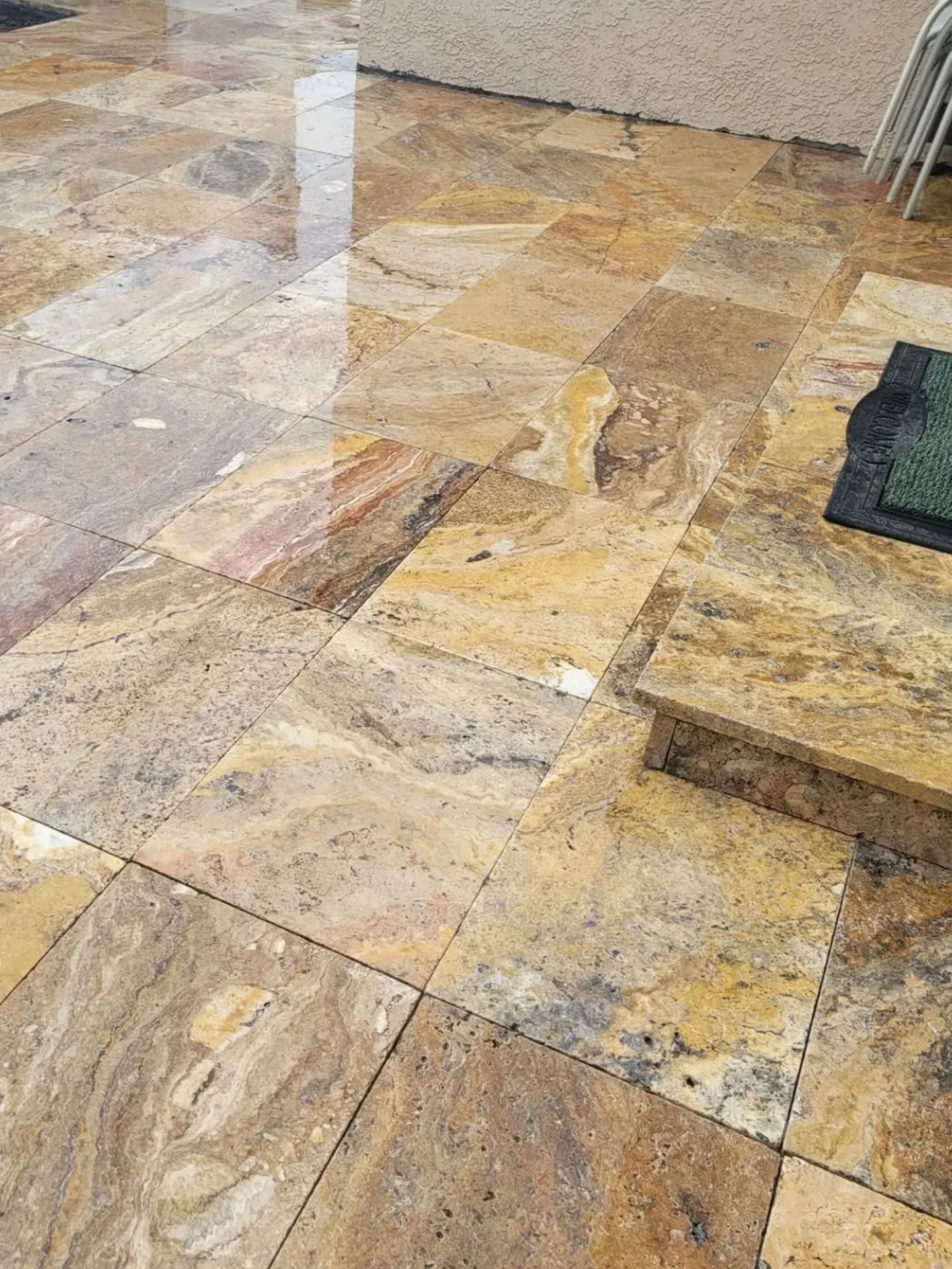 A close up of a tiled floor with stairs in the background.