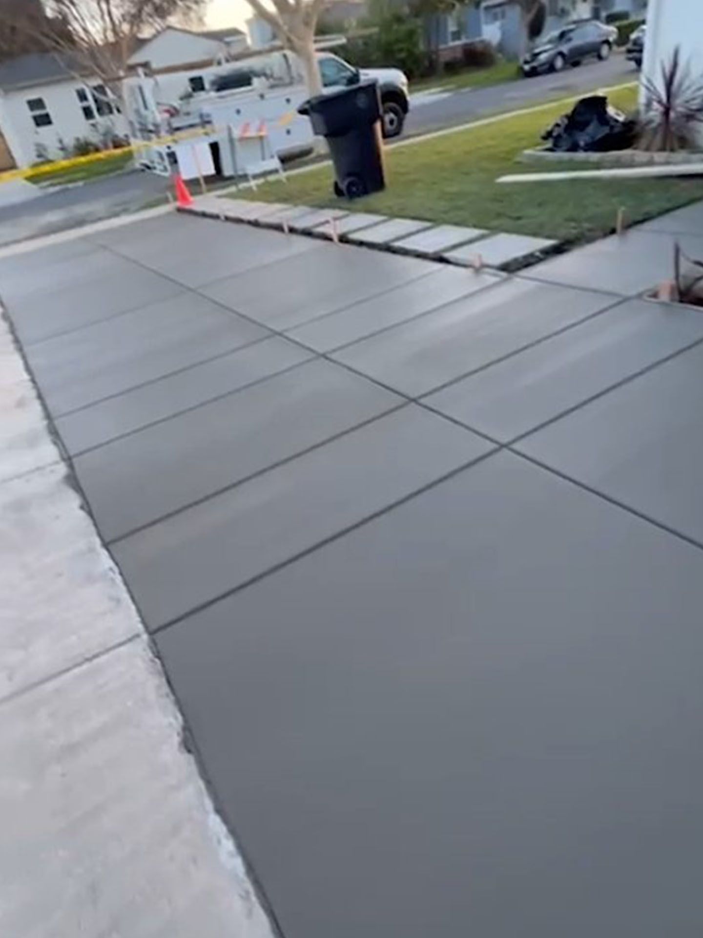A concrete driveway is being built in front of a house.