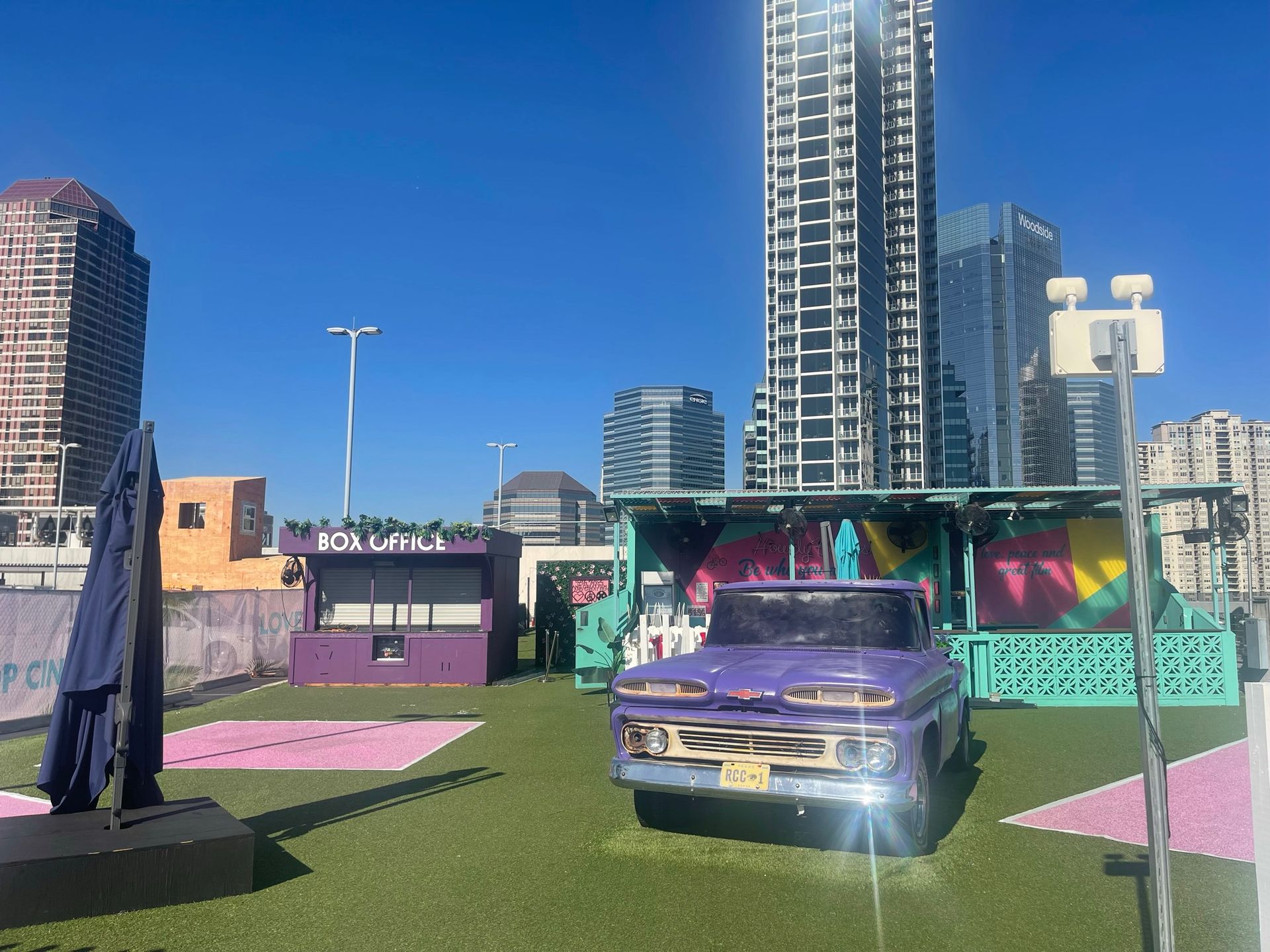 Outdoor cinema concession stand and ticket booth area with a parked car