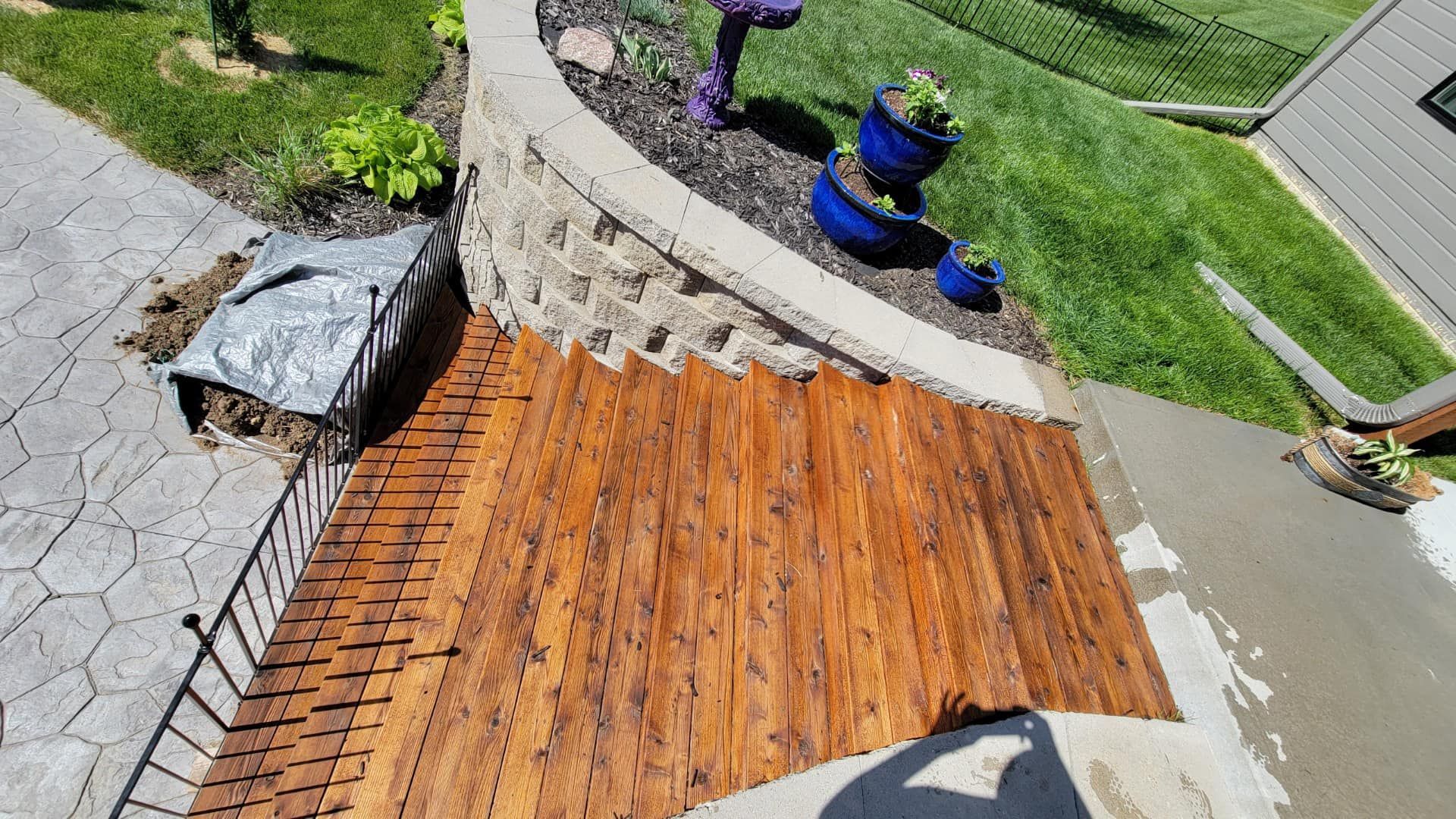 A white deck with a white railing is in front of a white house.