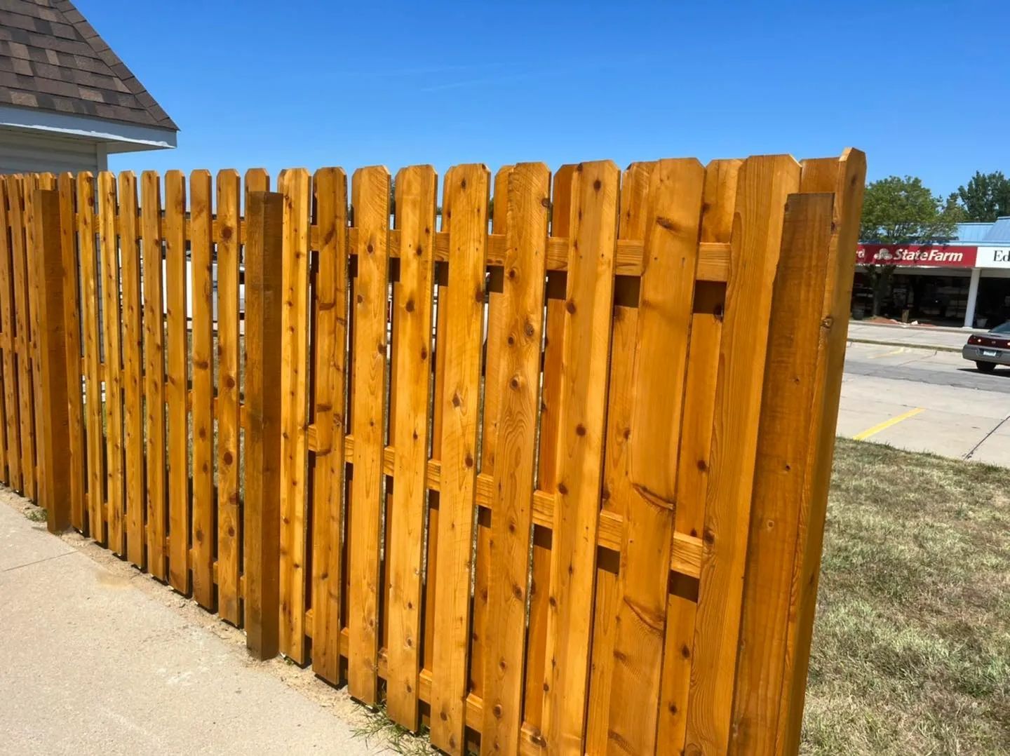 A wooden fence is sitting in the backyard of a house.
